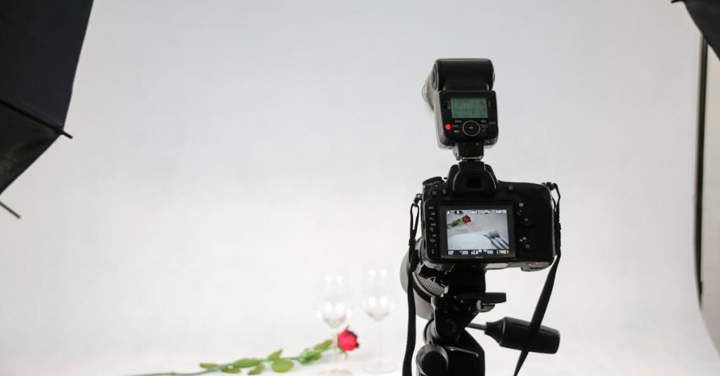 Camera setup in a photography studio capturing a rose and wine glasses.